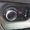 Close-up of the 2018 Chevrolet Cruze LT Turbos headlight control panel, featuring a circular dial for automatic mode, parking lights, and headlights. A smaller right-side dial adjusts dashboard brightness, with a textured surface surrounding the panel.