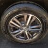 Close-up of a car tire mounted on a shiny silver alloy wheel bearing the Mazda logo. The JOYROAD GRAND TOURER tire is visible, as featured on the 2016 Infiniti QX60 AWD.