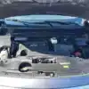 The image shows the open hood of a 2016 Infiniti QX60 AWD, highlighting the Infiniti logo and V6 on the engine cover. Components such as coolant, oil cap, and battery are visible, displaying a well-organized engine bay parked outdoors.