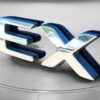 A shiny, metallic 3D EX logo sits on a smooth, circular gray platform inspired by the 2018 Kia Soul EX, set against a neutral background.