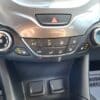 The 2017 Chevrolet Cruze 2LT Turbos climate control panel showcases buttons for fan speed, A/C, defrost, and temperature. The hazard light button is centrally located with a hands reflection visible on its sleek surface.
