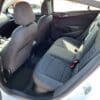 The image features the interior of a 2017 Chevrolet Cruze 2LT Turbo, viewed from the open back door. The gray fabric upholstery covers two front and two rear seats, with sunlight accentuating the simple and neat design.