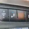 A close-up of three 2018 Hyundai Elantra Limited dashboard buttons: one with a headlight and plus sign, another with two cars and a blue light, and the third featuring a swerving car symbol labeled OFF.