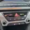 Close-up of a 2018 Hyundai Elantra Limited dashboard shows the controls for audio, air conditioning, and hazard lights. The passenger airbag indicator reads PASSENGER OFF, with air conditioning knobs and other buttons neatly arranged below.