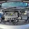 The open hood of a 2014 Hyundai Elantra GT reveals its engine compartment, with a GDI labeled engine cover. Visible components include the battery and fluid reservoirs, while the silver exterior adds to its sleek look.