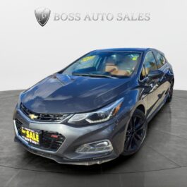 A 2017 Chevrolet Cruze Premier Hatchback in dark gray is shown in a showroom with a 