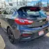 A dark gray 2017 Chevrolet Cruze Premier Hatchback is parked on a paved lot with its sleek rear and side visible, complete with taillights. The license plate reads Loaded under a partly cloudy sky.