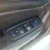 The close-up features the 2015 Chrysler 200 S AWDs drivers side door armrest, with intuitive buttons for window adjustment, mirror control, and door lock. The black panel with clear symbols emphasizes the cars advanced design.