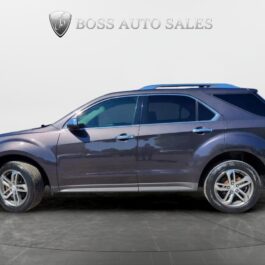 A 2016 Chevrolet Equinox LTZ AWD in dark blue is parked indoors on a gray floor, shown from the side. The background features a white wall with the Boss Auto Sales logo and text above the vehicle.