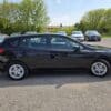 A 2017 Subaru Impreza Premium HB is parked on a gravel lot, surrounded by other vehicles and green trees in the background on a sunny day.