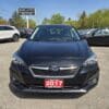 A 2017 Subaru Impreza Premium HB in black is parked among other cars, featuring a red license plate near a Boss Auto sign, with trees and blue sky behind.