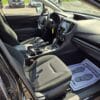 Interior of a 2017 Subaru Impreza Premium HB with black fabric seats, dashboard, steering wheel, center console, and a passenger floor mat that reads “Your Business is Appreciated!” with a footprint graphic.