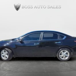 A black 2014 Nissan Altima 2.5 SL four-door sedan is parked indoors on a circular platform beneath the Boss Auto Sales logo, viewed from the side with silver alloy wheels and tinted windows.