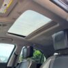 Interior view of a 2017 Chevrolet Equinox 2LT AWD with a partially open sunroof, two black leather front seats, and a clear sky with trees and power lines visible through the windows.