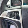 Close-up of a 2017 Chevrolet Equinox 2LT AWD steering wheel shows cruise control buttons (RES/+, SET/-, CANCEL, ON/OFF). The dashboard and part of the speedometer gauge are also visible in this SUVs interior.