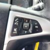 Close-up of a 2017 Chevrolet Equinox 2LT AWD steering wheel with black buttons for volume, source, hands-free calling, voice command, and audio muting, all highlighted by sleek silver trim and white icons.