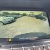 A rearview camera display in the 2017 Chevrolet Equinox 2LT AWD shows a parking lot with cars, yellow guide lines on the screen, and a warning message at the bottom: Check Surroundings For Safety.