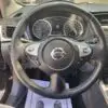 The image displays the interior of a 2017 Nissan Sentra SV, featuring a steering wheel with the iconic Nissan logo, speedometer and tachometer gauges on the dashboard, and a multimedia screen on the right, reflecting its modern design.