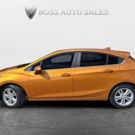 A side view of an orange 2017 Chevrolet Cruze LT Turbo hatchback with tinted windows, parked indoors on a gray floor. The plain white background features Boss Auto Sales and a shield logo above the car. A side view of an orange 2017 Chevrolet Cruze LT Turbo hatchback with tinted windows, parked indoors on a gray floor. The plain white background features Boss Auto Sales and a shield logo above the car.