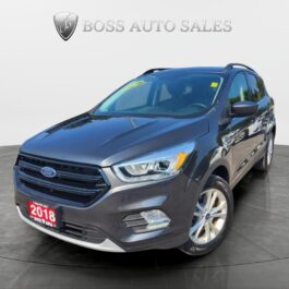 A dark gray 2018 Ford Escape SEL 4WD is showcased in a showroom with the Boss Auto Sales logo in the background, positioned to highlight its front and driver’s side, clear headlights, and sleek alloy wheels.
