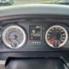 Close-up of the 2017 Dodge Ram 1500 ST 4X4 dashboard with a digital display showing 20°C, speed at 0 km/h, and an odometer reading of 121,615 km. It includes a tachometer and speedometer flanking the digital display in this rugged model.