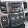 A close-up of the 2017 Dodge Ram 1500 ST 4X4s dashboard reveals a radio at GTA W1 Country RX 96.9 at 7:39am, with air conditioning dials set in a sleek black interior, and a newspaper peeking out, showcasing the rugged design.
