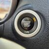 A close-up shows the 2017 Dodge Journey SEs push-button ignition system on a sleek black dashboard. The button, featuring ENGINE START STOP and encircled by OFF, ACC, and RUN labels, is accented by a keyless ignition symbol for a modern touch.