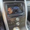 A close-up of a 2013 Ford Edge SEL V6 dashboard shows a digital display with the Ford logo and radio set to 94.9 FM. The screen offers phone connection and navigation, with media and climate controls below, all powered by its robust V6 engine.