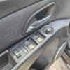Close-up of a 2015 Chevrolet Cruze 2LT driver-side door panel with window controls, side mirror adjustment knob, door handle, and speaker visible.