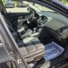 Open front passenger door of a 2015 Chevrolet Cruze 2LT, revealing black leather seats, a spotless interior, and a paper floor mat on the passenger side that says, YOUR BUSINESS IS APPRECIATED.