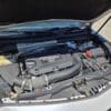 A close-up of the 2020 Cadillac XT4 Sport AWD engine under an open hood reveals a black TURBO-labeled cover along with various components, such as hoses, battery, and fluid reservoirs.