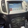 2017 Ford Edge SEL dashboard with touchscreen display shows radio tuned to 95.9 FM playing Slow Down the Days by The Glory Boys. Climate and audio controls are visible beneath the screen.