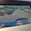 A 2017 Ford Edge SEL backup camera display shows a parking lot with several cars, colored reverse guide lines, and the Please check surroundings for safety message at the top of the screen.