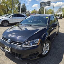 A black 2015 Volkswagen Golf is parked in a car dealership lot on a sunny day. Other vehicles and a Boss Auto sign are visible in the background.
