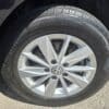 Close-up of a 2015 Volkswagen Golf 1.8T Highline wheel featuring a silver alloy rim, Pirelli P4 tire, and the VW logo at the center, all parked on sunlit asphalt.
