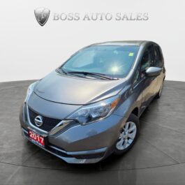 A 2017 Nissan Versa Note SV in grey is showcased on a circular platform in a showroom, facing slightly left, with the Boss Auto Sales logo displayed on the wall behind it.