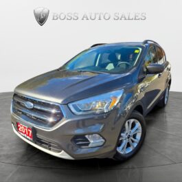 A gray 2017 Ford SUV is displayed in a showroom with Boss Auto Sales logo above it. The car is angled to show the front and drivers side, with a red license plate that reads 2017.