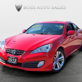 A vibrant red 2012 Hyundai Genesis 2.0T Premium with a sporty design and silver alloy wheels is showcased in a showroom, Boss Auto Sales signage behind it—a sleek package blending style and performance.