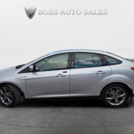 Side view of a silver 2014 Ford Focus SE parked indoors on a gray floor, with the Boss Auto Sales logo and text above on a white background.