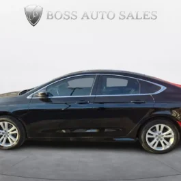 A side view of the 2015 Chrysler 200 Limited sedan parked indoors with the BOSS AUTO SALES name and a silver shield logo displayed above the vehicle, set against a plain white background.