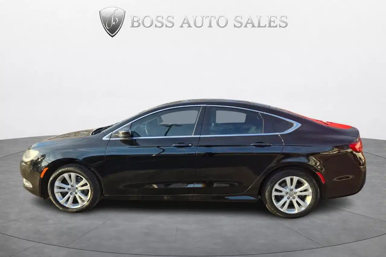 A side view of the 2015 Chrysler 200 Limited sedan parked indoors with the BOSS AUTO SALES name and a silver shield logo displayed above the vehicle, set against a plain white background.