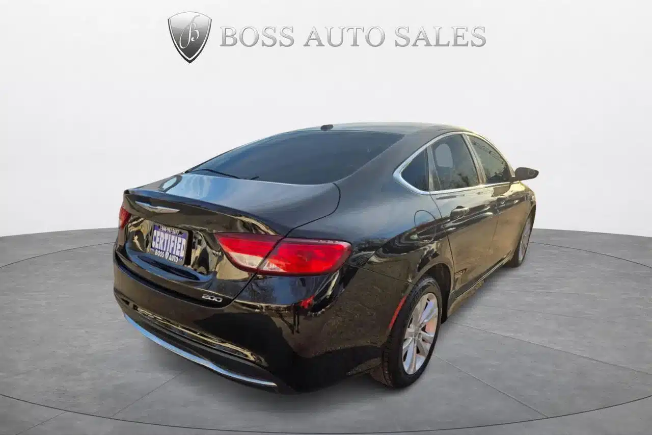 A black 2015 Chrysler 200 Limited sedan is parked in a showroom beneath the Boss Auto Sales logo and text. The vehicle is shown from the rear-left angle, displaying its tinted windows and dealership plate, which emphasize the sleek design of the Chrysler 200 Limited.