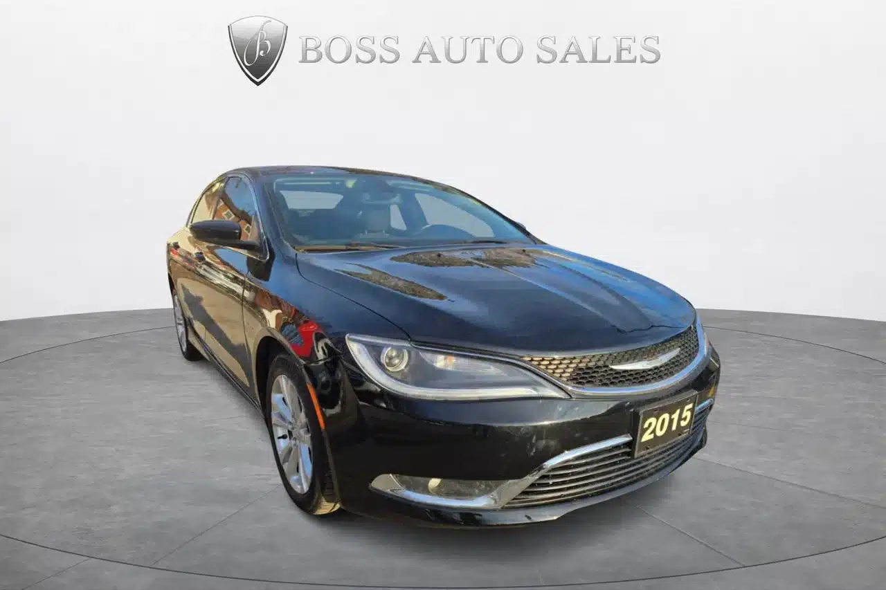 A black 2015 Chrysler 200 Limited sedan is displayed in a showroom with BOSS AUTO SALES on the wall behind it. This used Chrysler 200 Limited is clean and viewed from the front left angle.