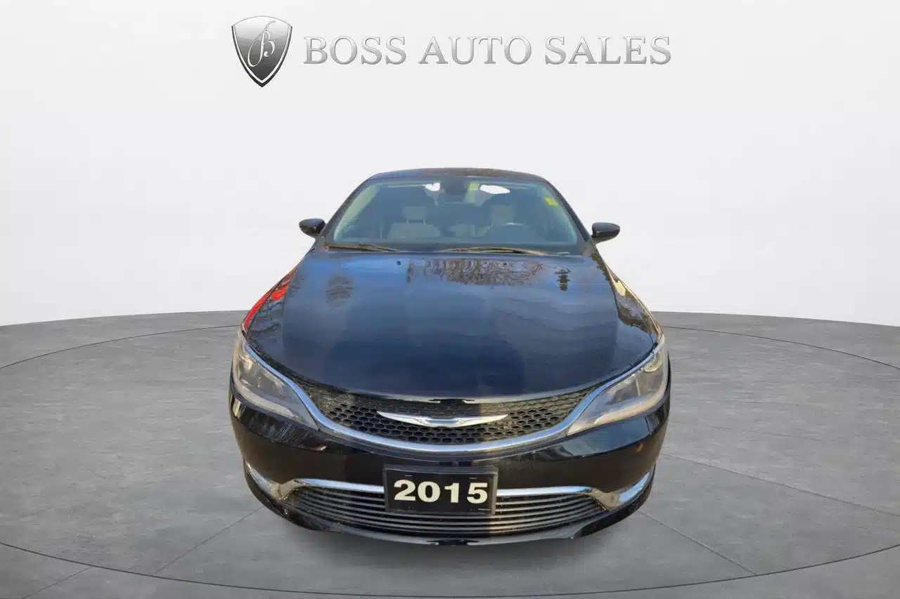 Front view of the 2015 Chrysler 200 Limited in black, parked indoors with the BOSS AUTO SALES logo and name visible on the white background wall behind the vehicle.