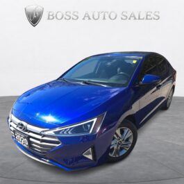A 2020 Hyundai Elantra Preferred sedan is parked in a showroom, angled to display the front and driver’s side, with BOSS AUTO SALES and its logo visible on the wall behind it.