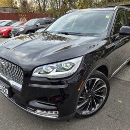 Black 2020 Lincoln Aviator Reserve AWD SUV parked in a car lot with other vehicles visible in the background.