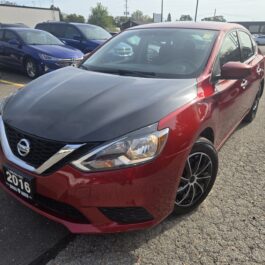 A red 2016 Nissan Sentra with a black hood parked in a car lot.