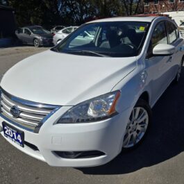 A white 2014 Nissan Sentra parked in a car dealership lot.